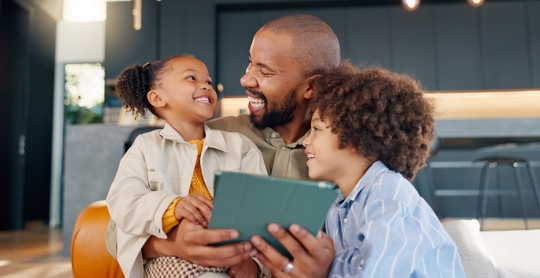 father and children playing with a tablet